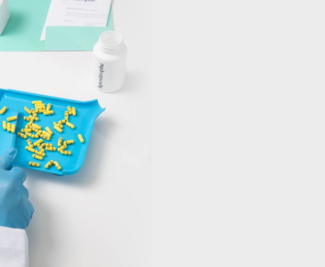 Top of desktop page image containing yellow pills being sorted on a blue tray by our pharmacist.